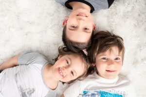 Trois enfants prenant la pose devant la caméra.